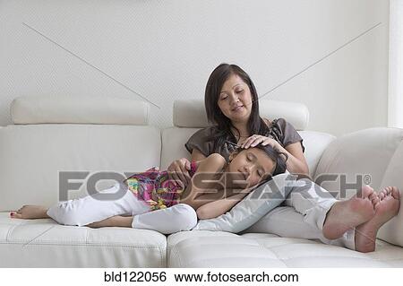 Asian mother and daughter relaxing on sofa View Large Photo Image Stock Photograph - Asian mother and daughter relaxing on sofa. Fotosearch