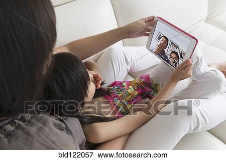 Asian mother and daughter talking to family on digital tablet View Large Photo Image Stock Photo - Asian mother and daughter talking to family on digital tablet. Fotosearch
