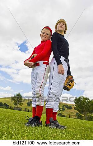 Stock Image - Baseball players standing back to back in field. Fotosearch