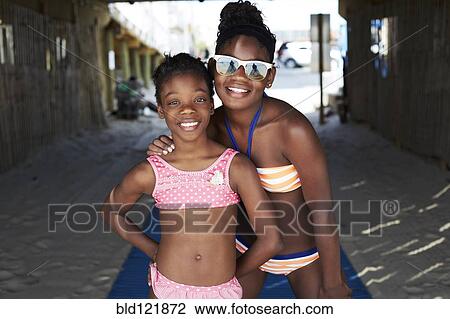 Stock Image - Black girls in bikinis smiling outdoors. Fotosearch