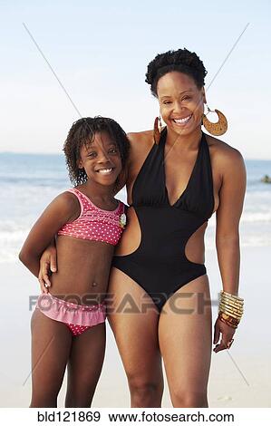 Black mother and daughter smiling on beach View Large Photo Image Stock Photo - Black mother and daughter smiling on beach. Fotosearch