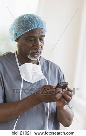 Black surgeon using cell phone View Large Photo Image Stock Image - Black surgeon using cell phone. Fotosearch