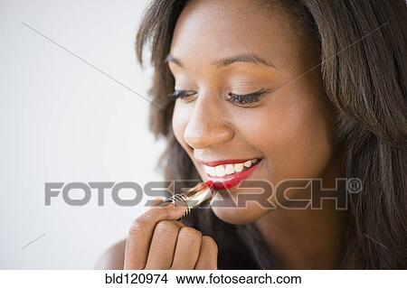 Black woman applying lipstick View Large Photo Image Picture - Black woman applying lipstick. Fotosearch