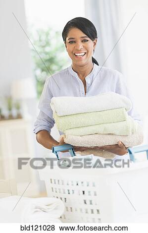 Black woman folding laundry View Large Photo Image Stock Photo - Black woman folding laundry. Fotosearch