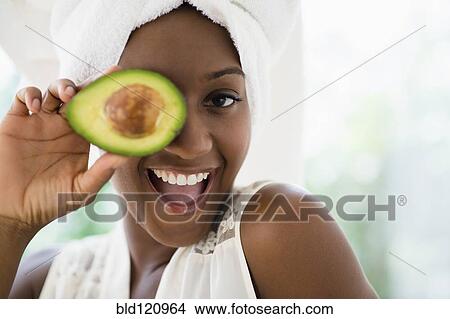 Black woman holding sliced avocado View Large Photo Image Picture - Black woman holding sliced avocado. Fotosearch
