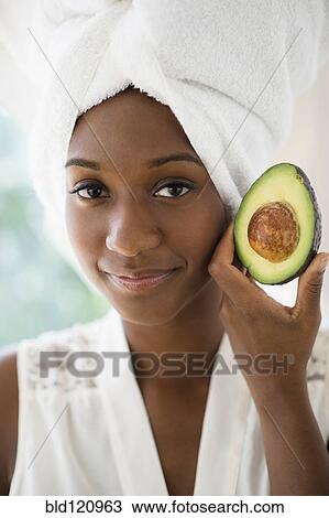 Black woman holding sliced avocado View Large Photo Image Stock Image - Black woman holding sliced avocado. Fotosearch
