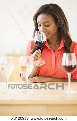 Stock Image - Black woman smelling wine. Fotosearch