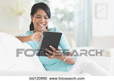 Black woman using digital tablet on sofa View Large Photo Image Stock Image - Black woman using digital tablet on sofa. Fotosearch