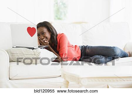 Black woman using laptop on sofa View Large Photo Image Stock Photography - Black woman using laptop on sofa. Fotosearch
