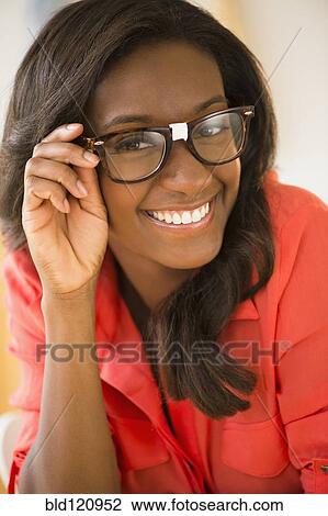 Stock Image - Black woman wearing taped glasses. Fotosearch
