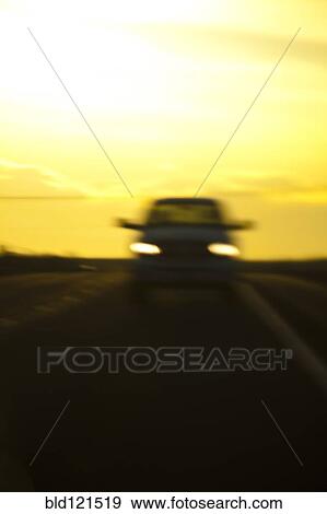 Stock Photo - Blurred view of car on road at night. Fotosearch