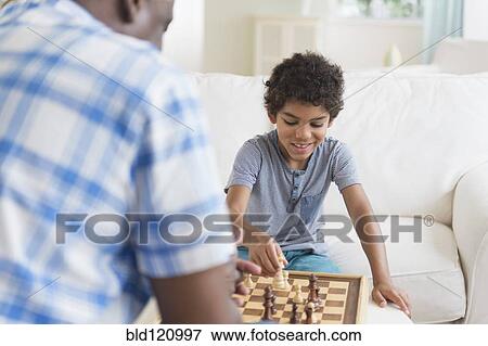 Boy playing chess with grandfather View Large Photo Image Stock Photo - Boy playing chess with grandfather. Fotosearch
