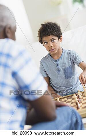 Stock Photo - Boy playing chess with grandfather. Fotosearch