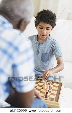 Stock Photo - Boy playing chess with grandfather. Fotosearch