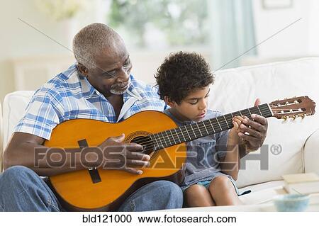 Boy playing guitar with grandfather View Large Photo Image Stock Image - Boy playing guitar with grandfather. Fotosearch