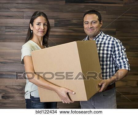 Business people carrying cardboard box in office View Large Photo Image Picture - Business people carrying cardboard box in office. Fotosearch