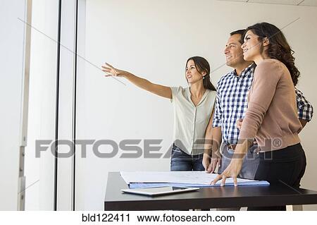 Business people examining blueprints in office View Large Photo Image Stock Image - Business people examining blueprints in office. Fotosearch