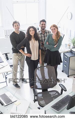 Business people smiling together in office View Large Photo Image Stock Photography - Business people smiling together in office. Fotosearch