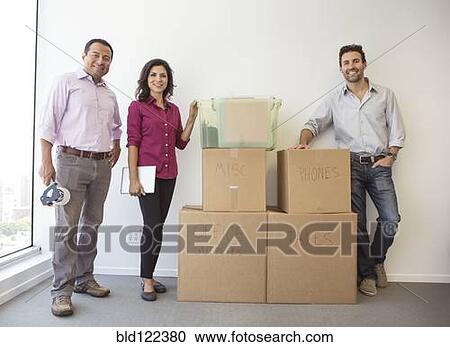 Stock Image - Business people standing in new office. Fotosearch