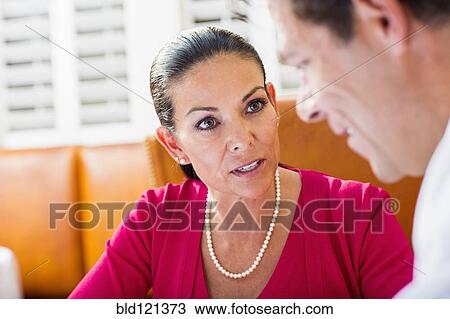 Stock Image - Business people talking at restaurant. Fotosearch