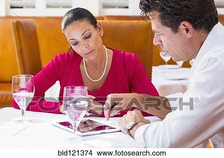 Business people using digital tablet at restaurant View Large Photo Image Picture - Business people using digital tablet at restaurant. Fotosearch
