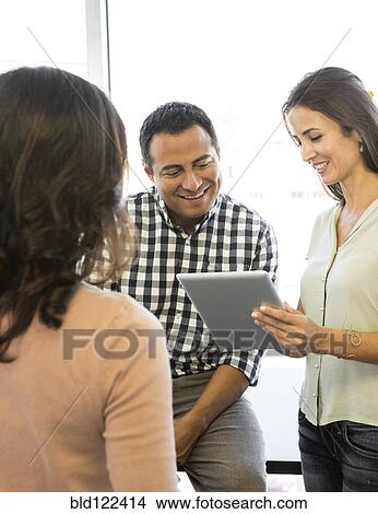 Picture - Business people using digital tablet in office. Fotosearch