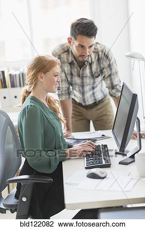 Stock Image - Business people working together in office. Fotosearch