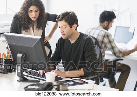 Stock Photo - Business people working together in office. Fotosearch