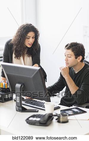 Stock Photo - Business people working together in office. Fotosearch