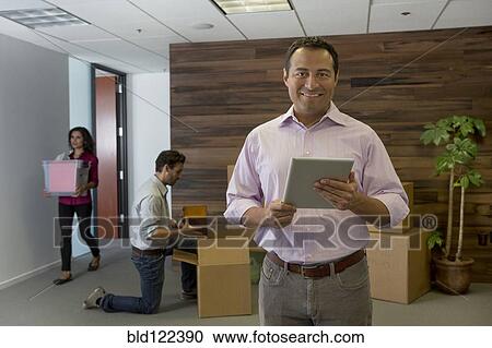 Stock Image - Businessman using digital tablet in office. Fotosearch