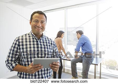 Businessman using digital tablet in office View Large Photo Image Stock Photo - Businessman using digital tablet in office. Fotosearch