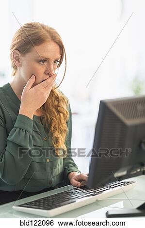 Businesswoman gasping at computer in office View Large Photo Image Stock Photograph - Businesswoman gasping at computer in office. Fotosearch