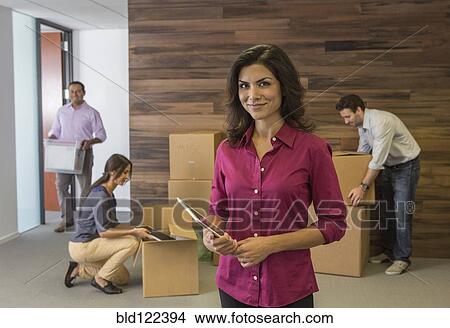 Picture - Businesswoman smiling in new office. Fotosearch
