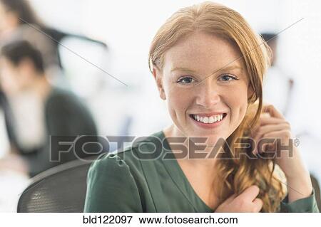 Stock Photo - Businesswoman smiling in office. Fotosearch