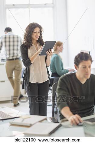 Stock Image - Businesswoman using digital tablet in office. Fotosearch