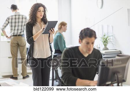 Stock Photo - Businesswoman using digital tablet in office. Fotosearch