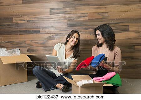 Stock Photo - Businesswomen using digital tablet in new office. Fotosearch