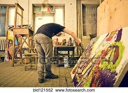 Stock Image - Caucasian artist painting in studio. Fotosearch
