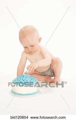 Picture - Caucasian baby boy playing with cake. Fotosearch