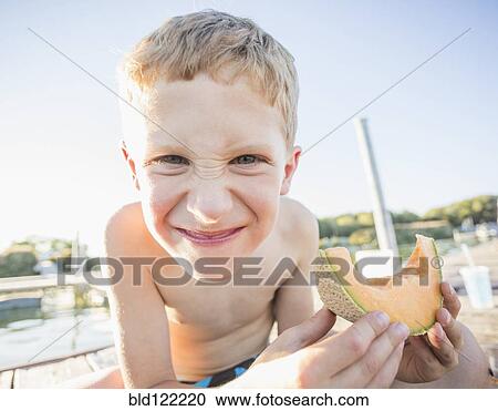 Caucasian boy eating cantaloupe slice View Large Photo Image Stock Image - Caucasian boy eating cantaloupe slice. Fotosearch