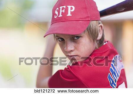 Stock Image - Caucasian boy playing baseball outdoors. Fotosearch
