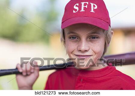 Stock Image - Caucasian boy playing baseball outdoors. Fotosearch