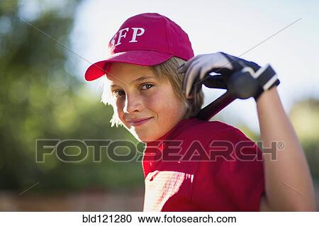 Stock Image - Caucasian boy playing baseball outdoors. Fotosearch