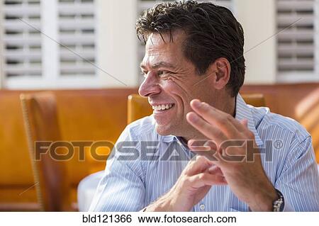 Stock Photograph - Caucasian businessman smiling in restaurant. Fotosearch