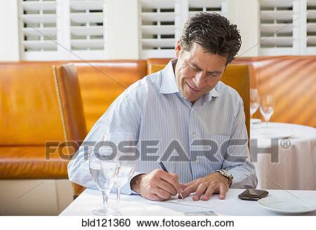Caucasian businessman working in restaurant View Large Photo Image Stock Image - Caucasian businessman working in restaurant. Fotosearch