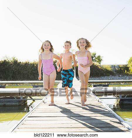 Caucasian children running on dock View Large Photo Image Stock Image - Caucasian children running on dock. Fotosearch