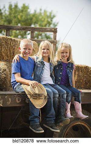 Caucasian children sitting on truck on farm View Large Photo Image Stock Photo - Caucasian children sitting on truck on farm. Fotosearch