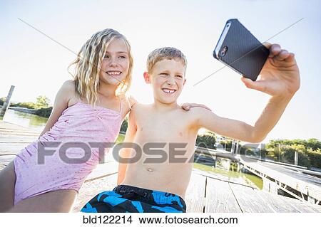 Caucasian children taking selfie with cell phone View Large Photo Image Picture - Caucasian children taking selfie with cell phone. Fotosearch