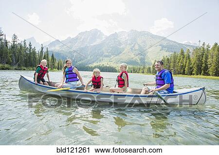 Stock Image - Caucasian family in canoe on lake. Fotosearch