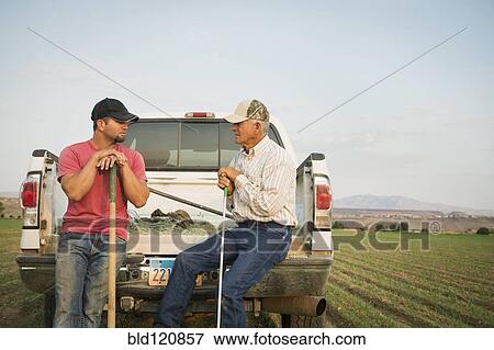 Caucasian farmers working in crop field View Large Photo Image Stock Photo - Caucasian farmers working in crop field. Fotosearch